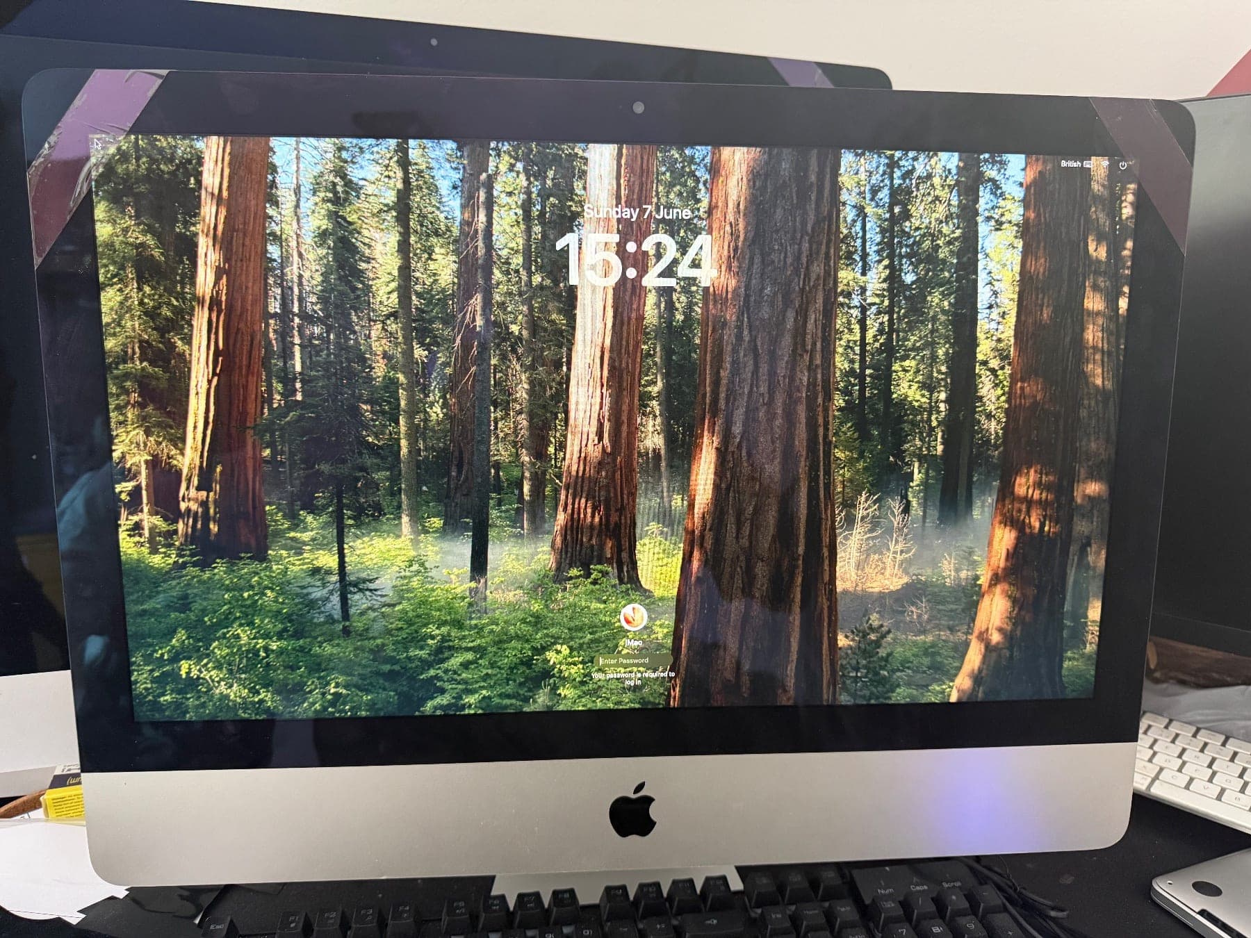 Reassembled iMac powered on and showing the macOS lock screen